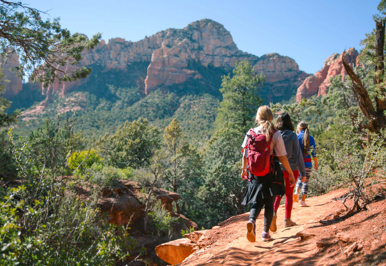 Village Clubs members hike at Camelback, enjoying scenic trails, vibrant red rocks, and community under a clear Arizona sky.