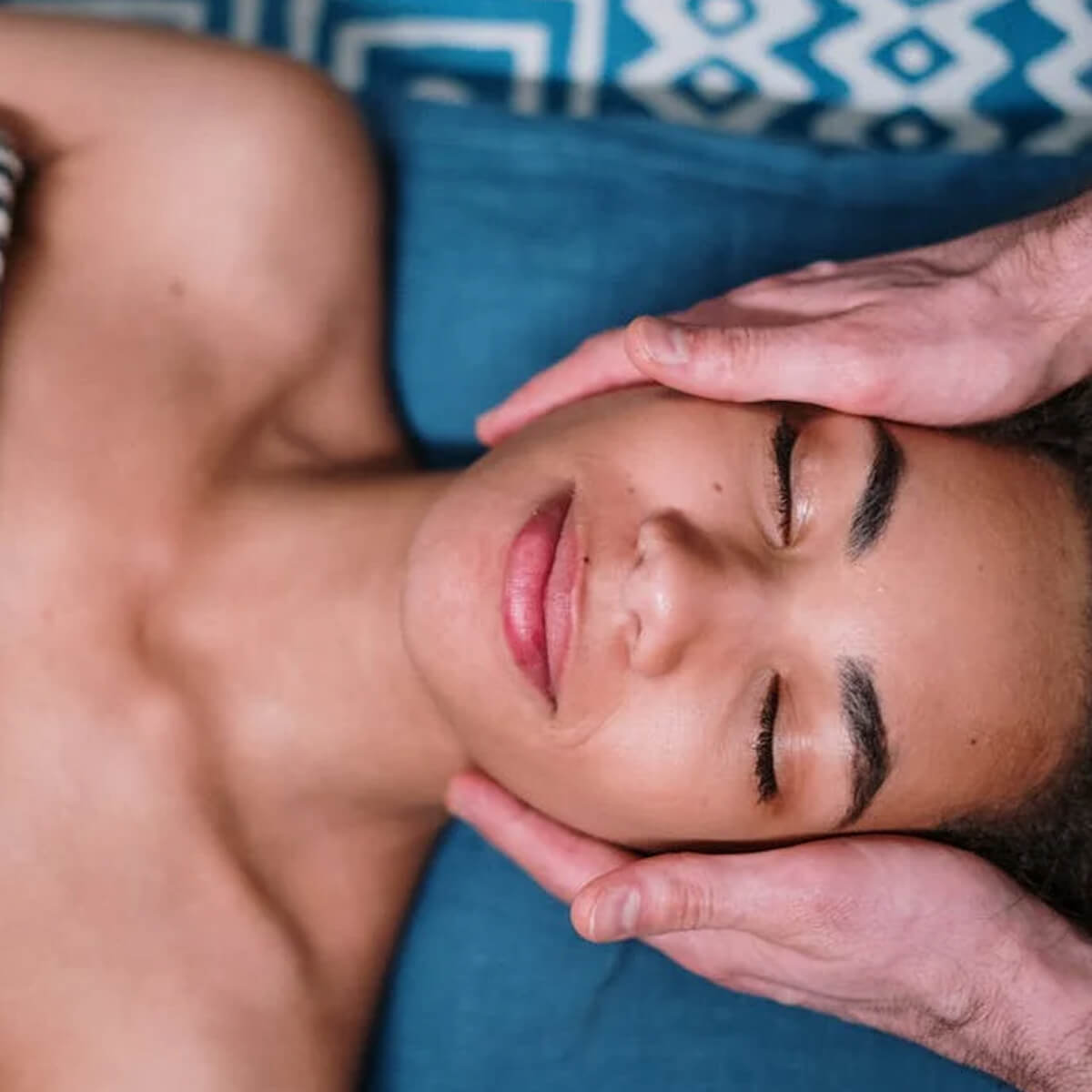A guest receives a soothing facial massage at Village Clubs Camelback in Arizona, relaxing as skilled hands cradle their head.