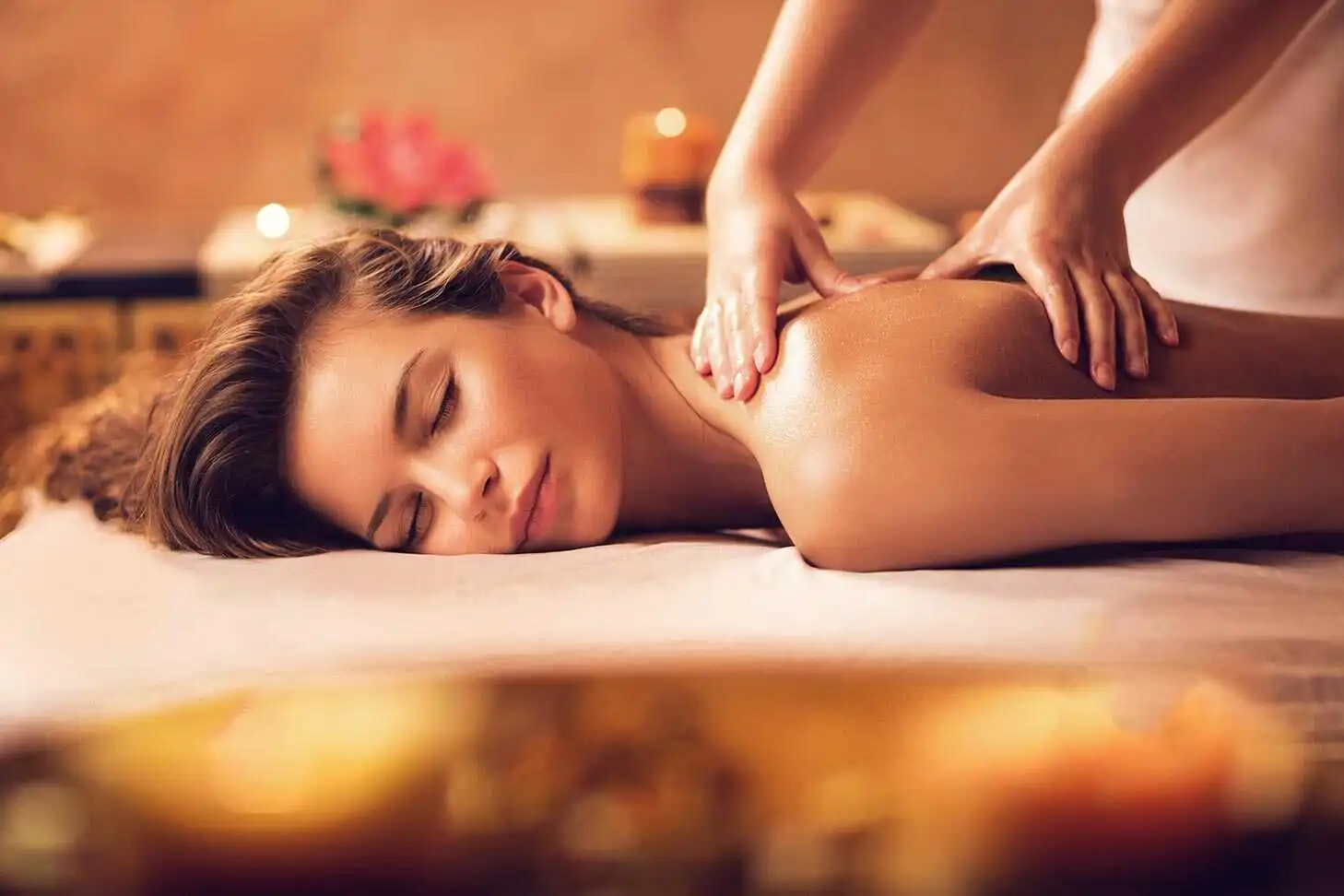 A guest enjoys a relaxing back massage at Village Clubs Camelback, with soft lighting and soothing ambiance enhancing the experience.